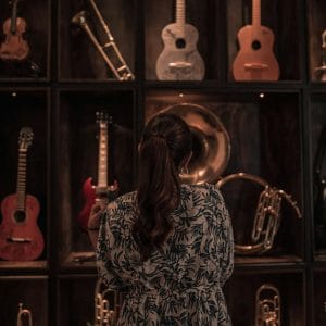 back view of a woman looking at musical instruments on shelves